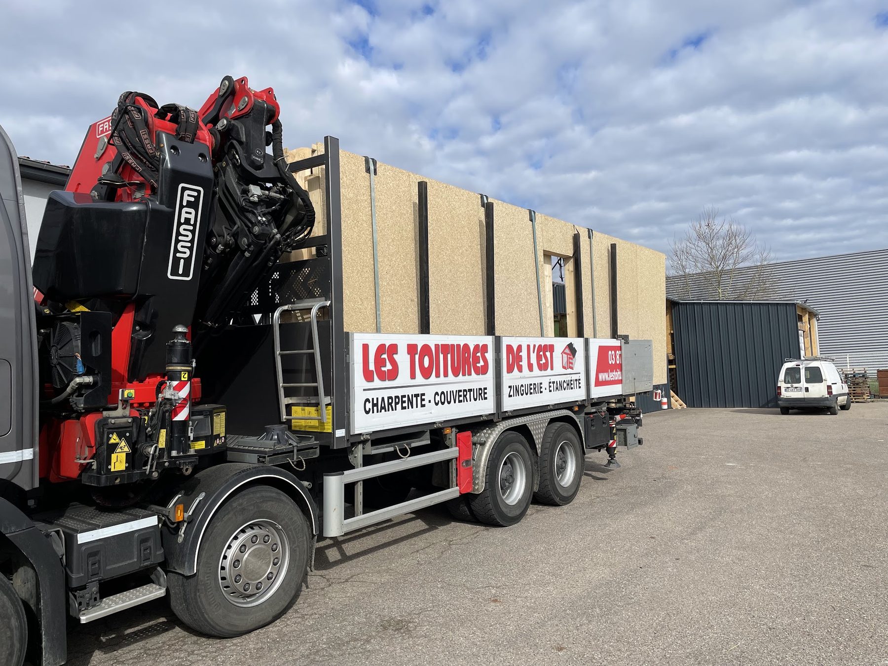 Camion-grue Les Toitures de l'Est chargé
