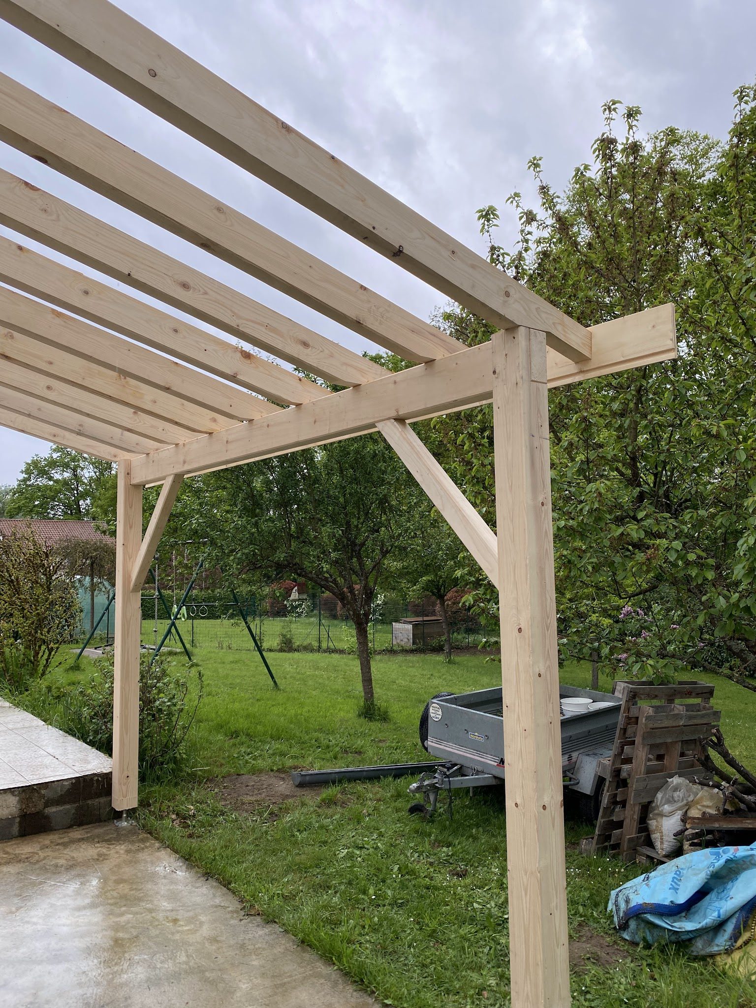 Auvent en bois neuf dans un jardin